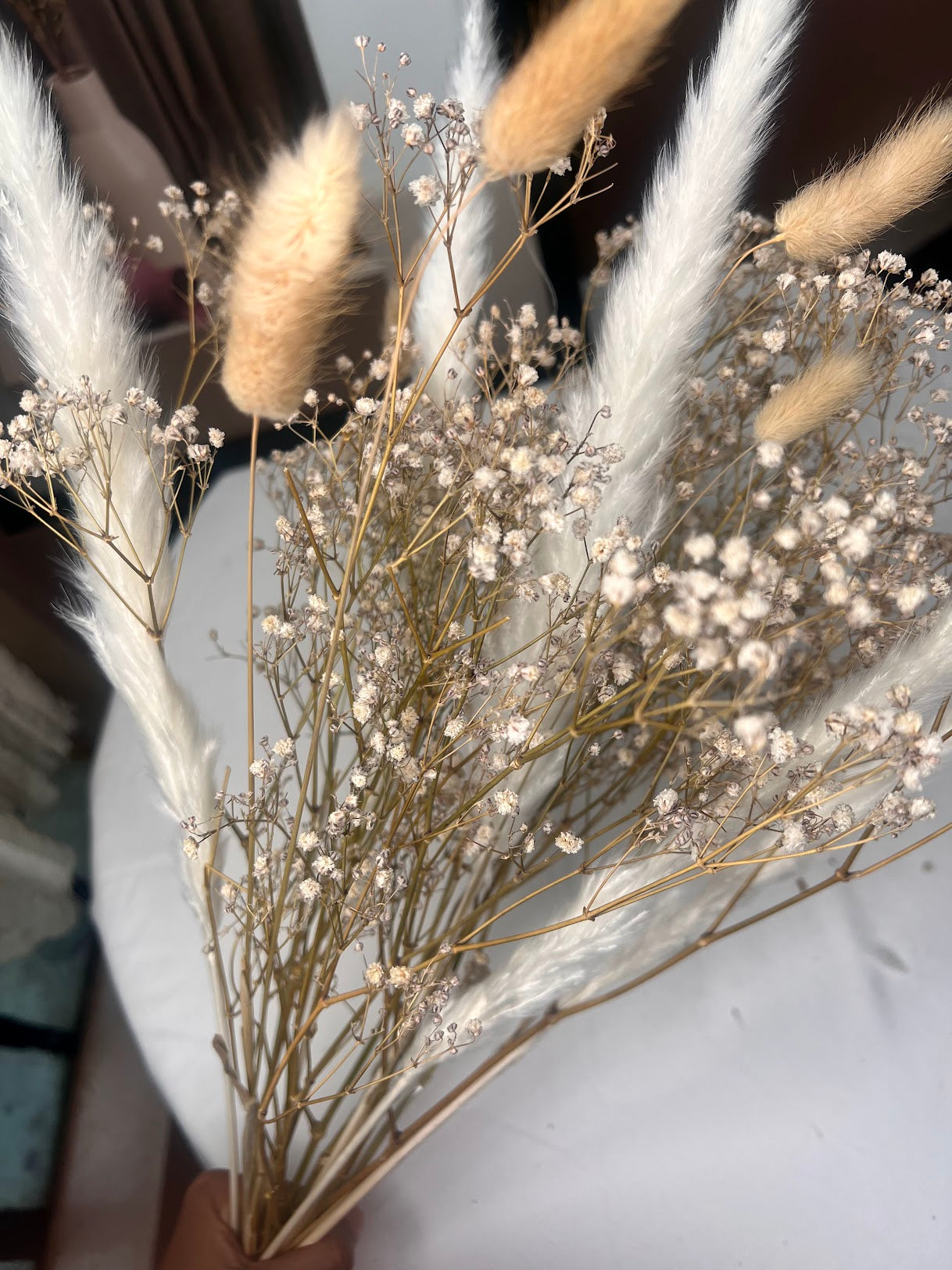 Bouquet of dried baby's breath flowers with accents of bunny tail and small pampas grass.