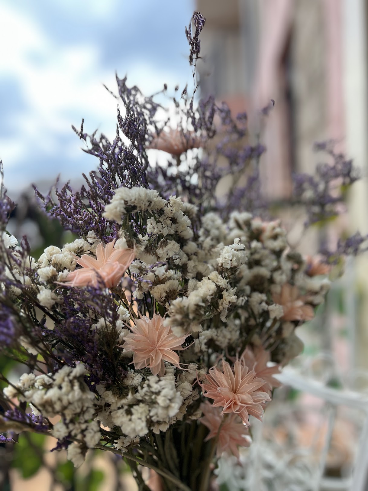 Bouquet of dried flowers with purple, pink and white blooms against a blurred background