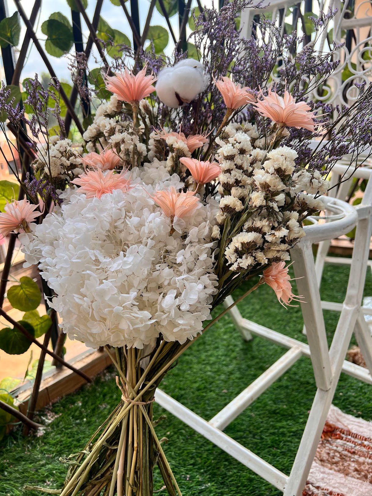 Bouquet of white and pink preserved flowers with a chair in the background