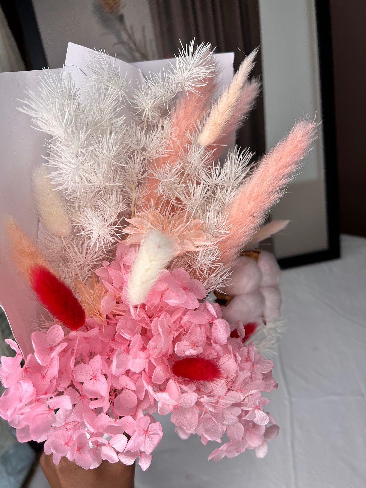 Pink flowers posy bouquet with held by hand. dried preserved flowers posy.
