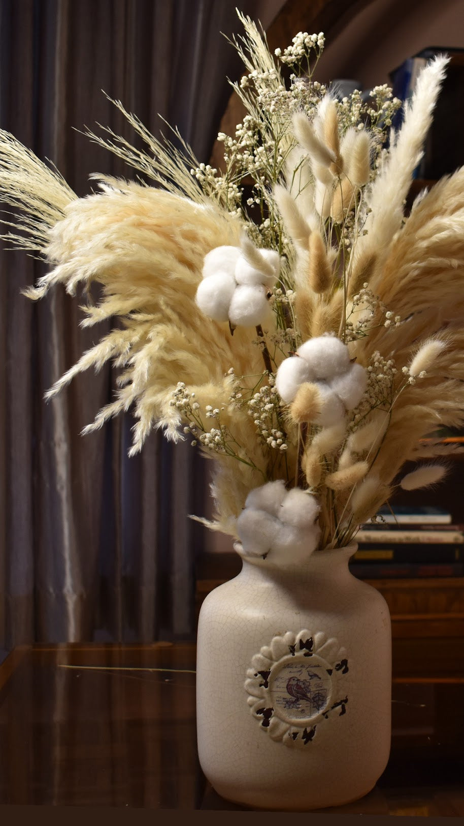 Decorative vase with dried plants and cotton in a room setting