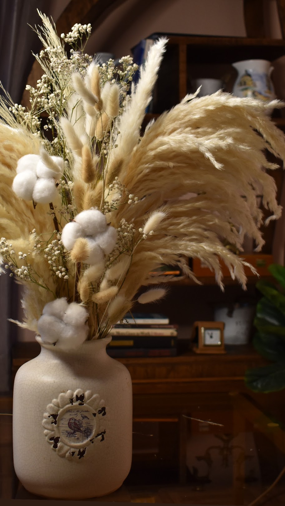 Decorative vase with dried plants and cotton in a home setting