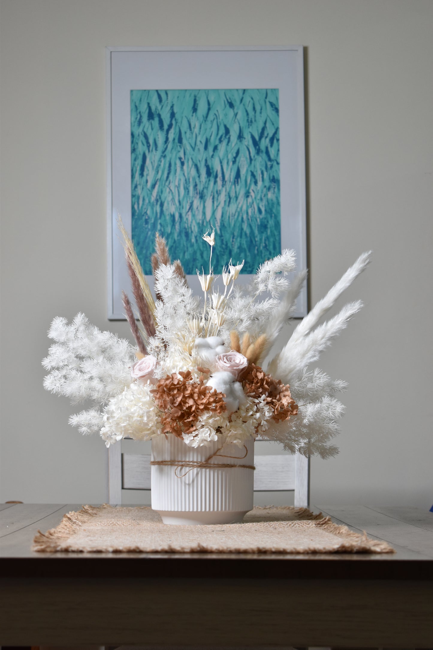 The Issadora muted nude colours preserved flower arrangement set on a dining table.