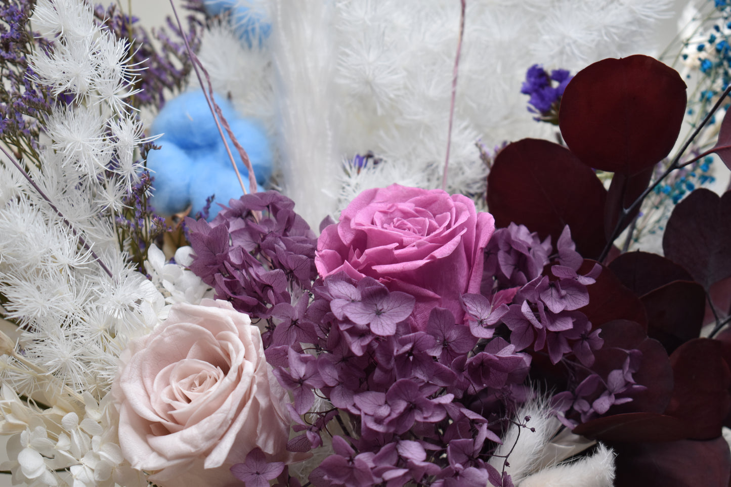 Dried flowers arrangement set on a 6-seater dining table from kenyan lady fleur contains preserved roses, eucalyotus, hydrangea, penglai pine, caspia, statice, babys breath, bunny tails, cotton stems and star anise.
