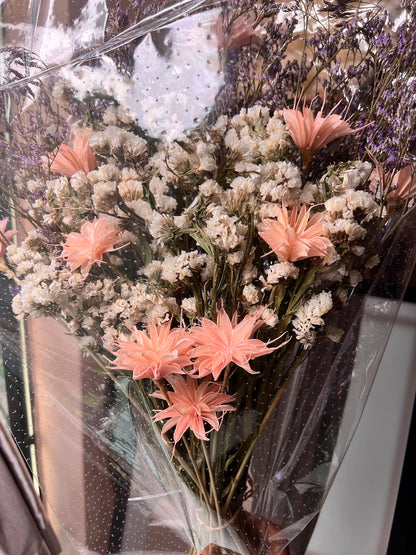 Bouquet of pink and white flowers in a clear vase with water droplets on the glass.