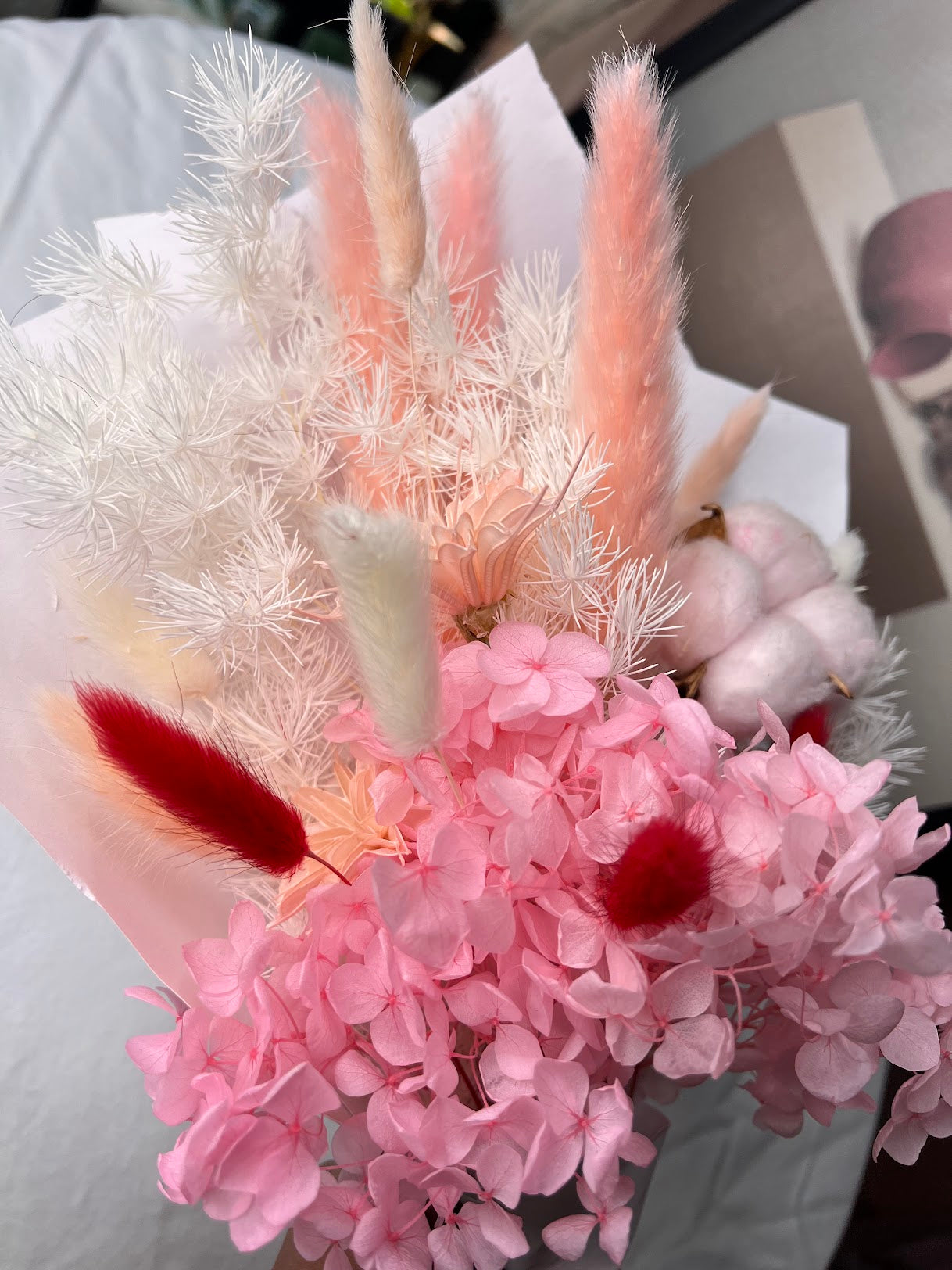 Pink flowers posy bouquet with held by hand. dried preserved flowers posy pampas grass kenya
