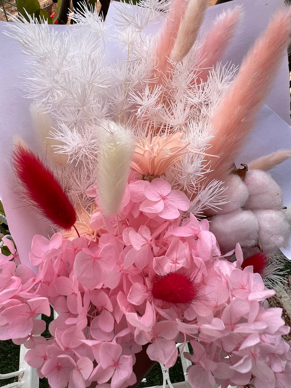 Pink flowers posy bouquet with held by hand. dried preserved flowers posy.