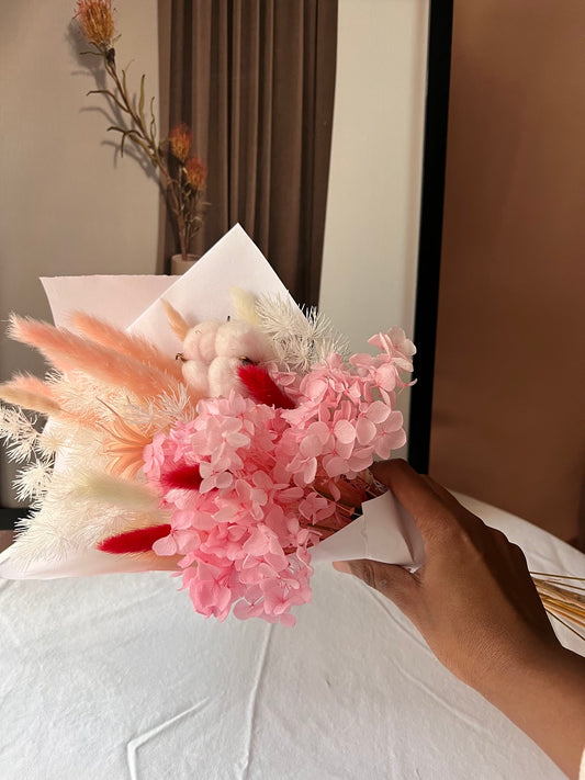 Pink flowers posy bouquet with held by hand. dried preserved flowers posy.