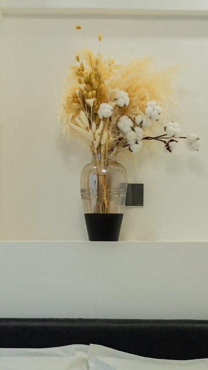 Arrangement with beige pamas grass and other preserved flowers from Kenyan Lady Fleur dried flowers store on a headboard.