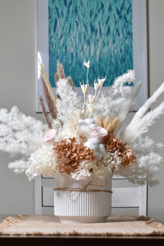 The Issadora muted nude colours preserved flower arrangement on dining table.
